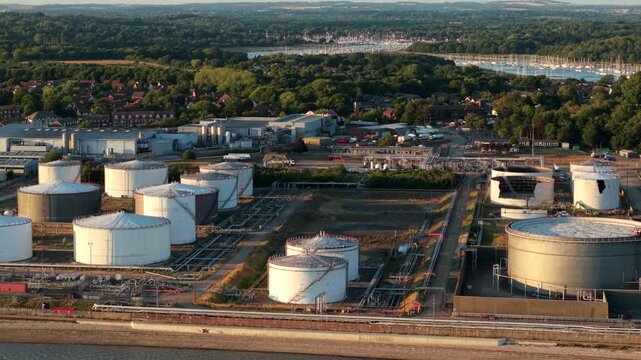 Aerial view of the industrial oil, LPG, and LNG storage terminal featuring large white tanks and pipelines in Hamble-le-Rice, England, United Kingdom.