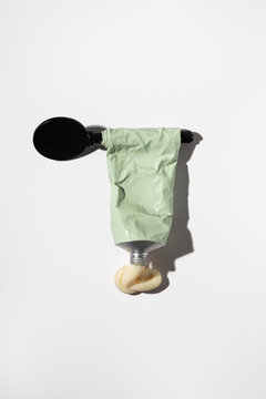 Minimal still life of toothpaste tube and black spoon