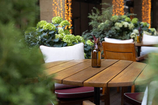 Cozy outdoor restaurant table with greenery and warm lights