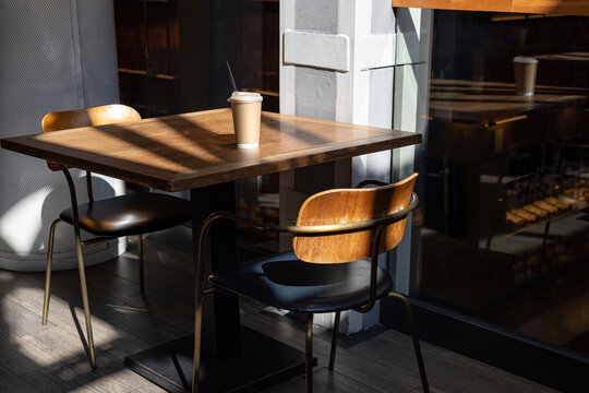 Sunlit wooden table in a modern food hall restaurant
