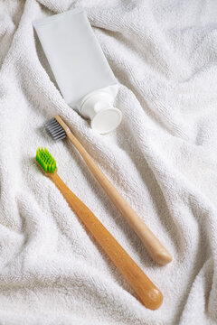 Bamboo toothbrush and toothpaste on towel for morning routine