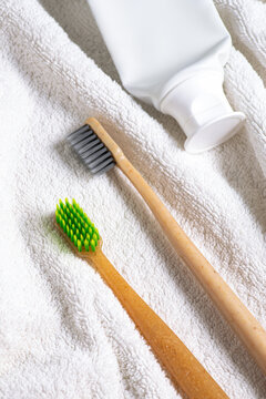 Bamboo toothbrush and toothpaste on towel for dental care