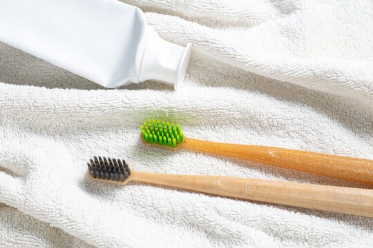 Bamboo toothbrush and toothpaste on towel for dental care