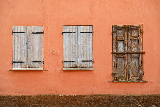 Vintage wooden window on a weathered plaster wall of an historic house