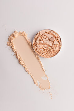 Crushed compact powder with beige makeup smear close-up