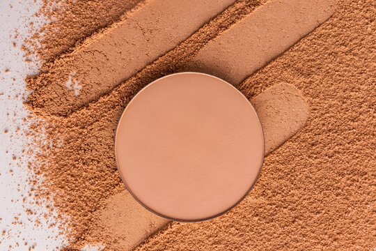Compact powder makeup swatch with warm nude pigment
