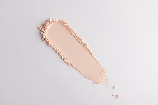 Beige compact powder smear on minimalist background
