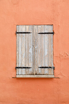 Vintage wooden window on a weathered plaster wall of an historic house