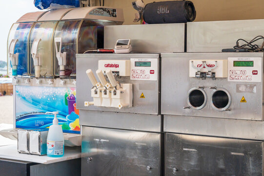 Cannes, France - August 04, 2026: Multiple beverage and ice cream machines are set up outdoors, with a JBL speaker and other items on top