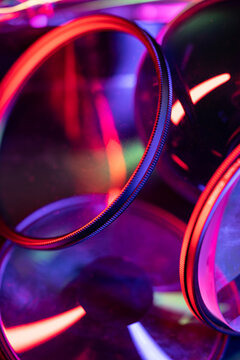 Neon illuminated camera lens filters in abstract composition