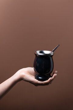 Female hand hold mate cup with metal straw