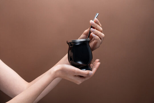 Female hand hold mate gourd with metal straw