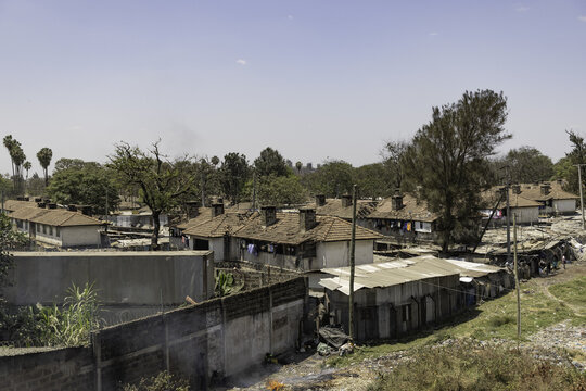 View of a residential neighborhood with simple houses, tiled roofs, and trees in Nairobi, Nairobi County, Kenya.
