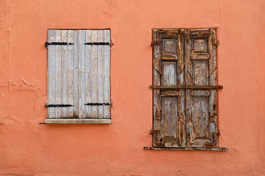 Vintage wooden window on a weathered plaster wall of an historic house
