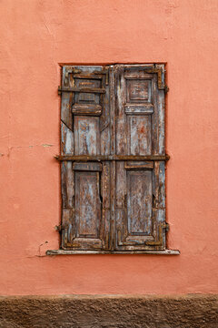 Vintage wooden window on a weathered plaster wall of an historic house