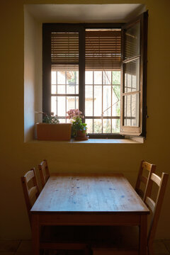 Rustic dining table by open window in Mura village