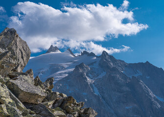 Obraz premium Alpine glacier and rugged mountain peaks under dramatic clouds in the French Alps, Chamonix, France