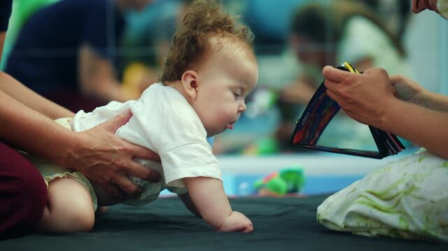 Baby learning to crawl during a physiotherapy session, supported by a therapist, improving development and sensory perception