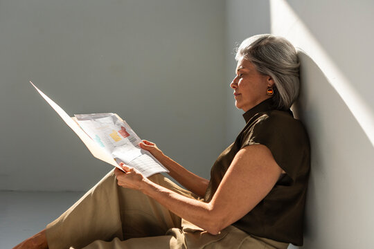 Mature businesswoman reviewing documents while seated indoors