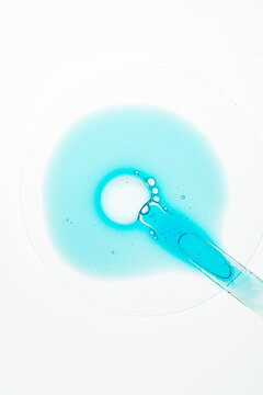 Blue serum bubbles and pipette on laboratory glass