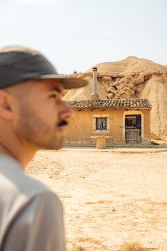 Man beside rustic house in Bardenas Reales desert, Spain