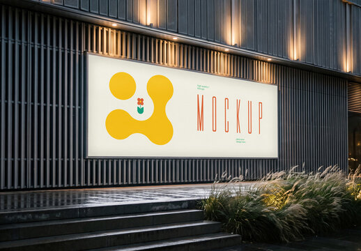 Illuminated Billboard Mockup on Modern Building Facade at Night