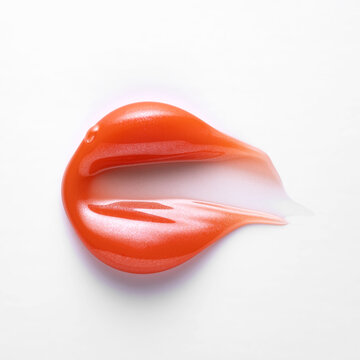 Red lip gloss smear on white background