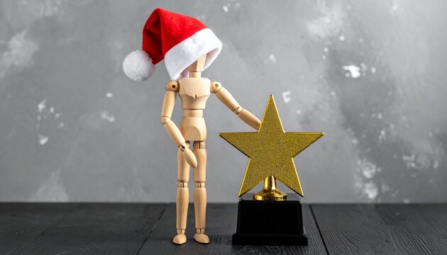 Wooden Artist Mannequin Wearing Santa Hat Standing Beside Gold Star Trophy Symbolizing Christmas Achievement, Year-End Award, Holiday Success, and Recognition