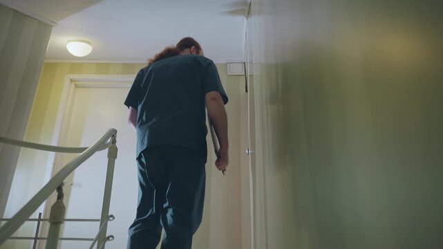 Black paramedic approaches upstairs apartment door, steady climb on narrow staircase, hand on rail, holds clipboard and stethoscope, quiet corridor, focused professional preparing patient contact