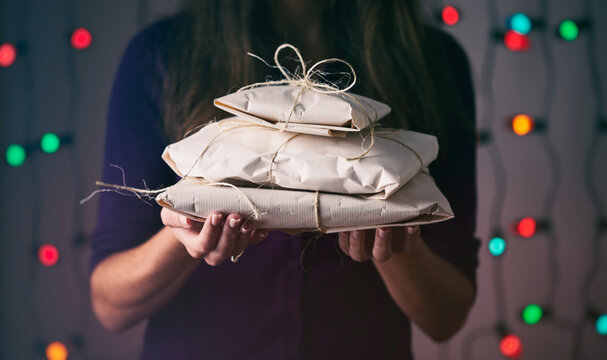 Christmas: Holding A Stack Of Simply Wrapped Christmas Presents
