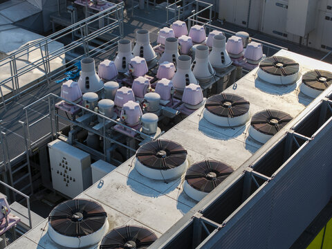 Aerial view of an AI data center rooftop featuring numerous industrial cooling fans and ventilation units arranged in rows for efficient thermal management in Poland.