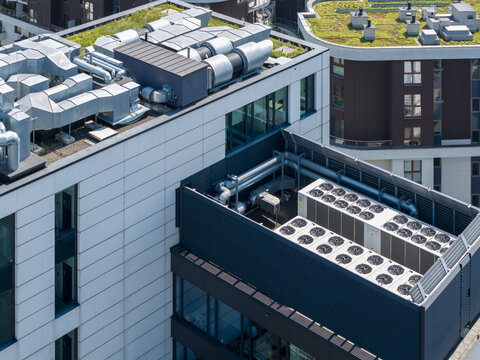 Aerial view of an AI data center cooling system on a modern building rooftop with ventilation ducts and green roof elements in Poland.