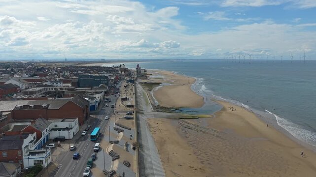 Aerial drone view of Redcar Beach on a summer day, wind turbines in the distance