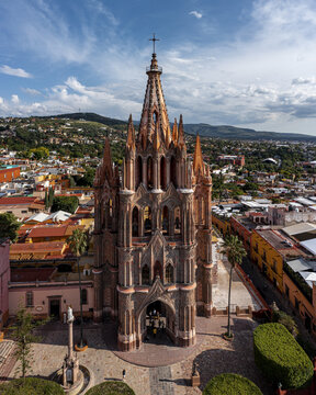 Aerial view of the iconic Parroquia de San Miguel Arcangel with its distinctive pink neo-Gothic spires rising above the colonial rooftops of San Miguel de Allende, Guanajuato, Mexico.