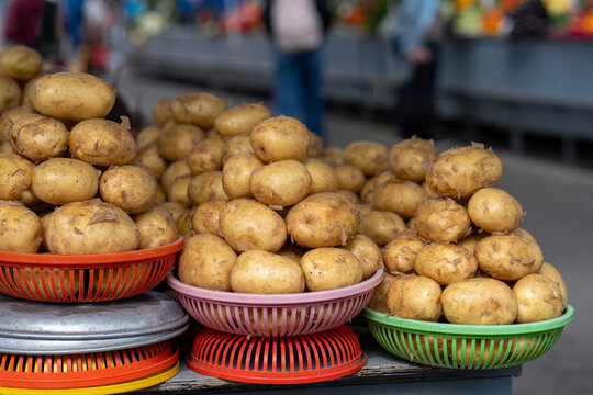 Photo showing fresh potatoes on a stand at a farmers market. Raw potatoes on the shelf in grocery store