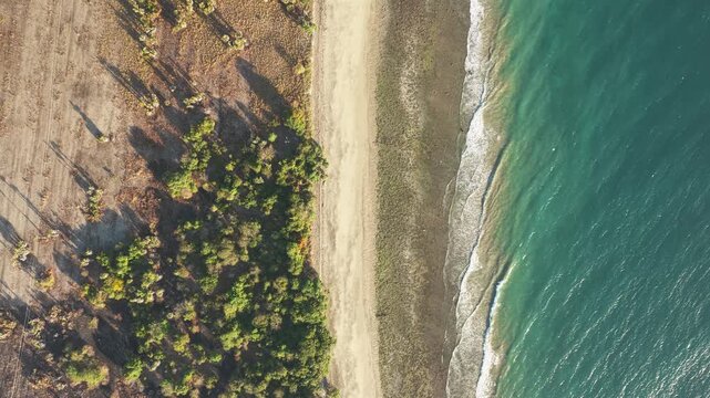 Aerial view of KANDORA Luxury Villas coastline with sandy beach and turquoise sea in Kecamatan Pandawai, Nusa Tenggara Timur, Indonesia.