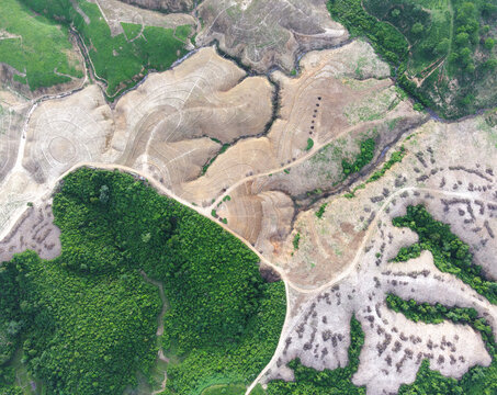 Aerial view of deforested land and patches of green forest in the hilly terrain of Chattogram, Chittagong Division, Bangladesh.