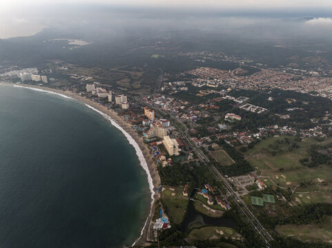 Aerial view of the coastline of Zihuatanejo with hotels, sandy beaches, and lush green vegetation along the Pacific Ocean in Zihuatanejo, Guerrero, Mexico.