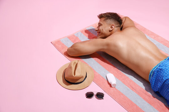 Happy man sunbathing on pink background. Space for text