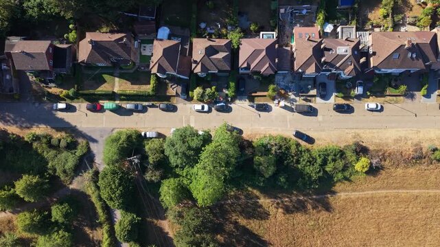 Aerial drone footage of a residential estate in Guildford, Surrey, England, showcasing housing, streets, gardens, green spaces, and the surrounding suburban landscape.