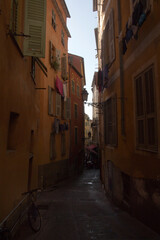 Fototapeta premium Narrow old town street with ochre facades, Nice, France