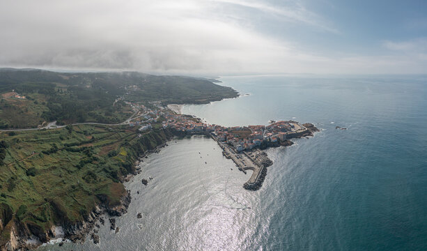 Aerial view of the coastal town of Caion with its harbor, rocky coastline, and buildings in Caion, A Coruna, Spain.