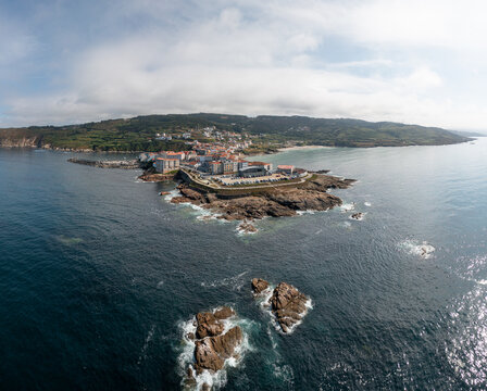 Aerial view of the coastal town of Caion with its rocky shoreline, historic buildings, and surrounding Atlantic waters in Caion, A Coruna, Spain.