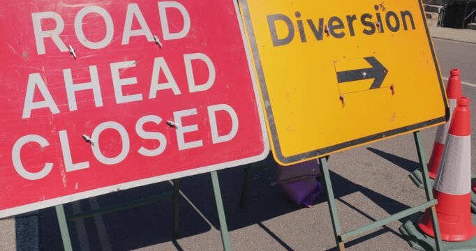Road closed street sign &ndash; Emergency services diverted traffic highway road sign in the event of a roadblock. Travel safety on street diversion. High visibility red signage marking temporary closure.