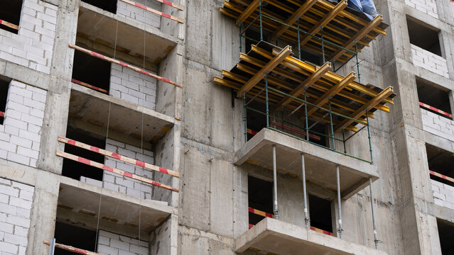 Unfinished residential building with concrete structure and temporary formwork, showing the process of urban development, construction and modern architecture.