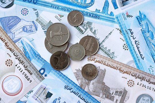 UAE dirham money banknotes and coins on table. United Arab Emirates cash bills of AED currency