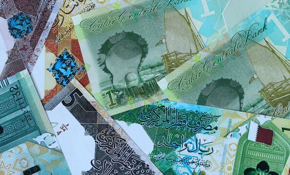 Qatari riyal money bills in pile. Big amount of Qatar QAR currency cash close up. Concept of casino
