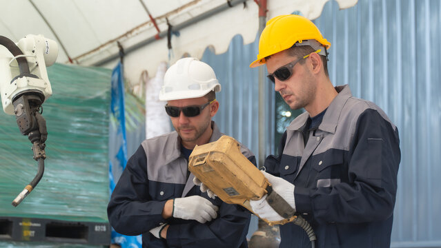 Maintenance factory technician discussing inspection findings on Robotic Production Equipment Inside a Modern Factory