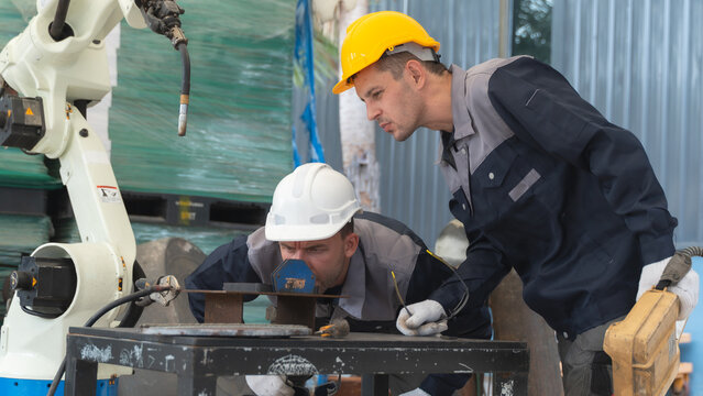 Industrial Workers inspecting equipment at close range While Evaluating Automated Machinery and Robotic Equipment
