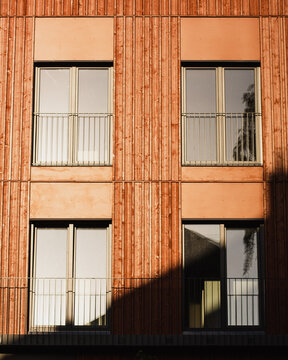 View of modern sustainable architecture featuring a timber facade with wooden cladding and geometric window patterns in Riga, Latvia.